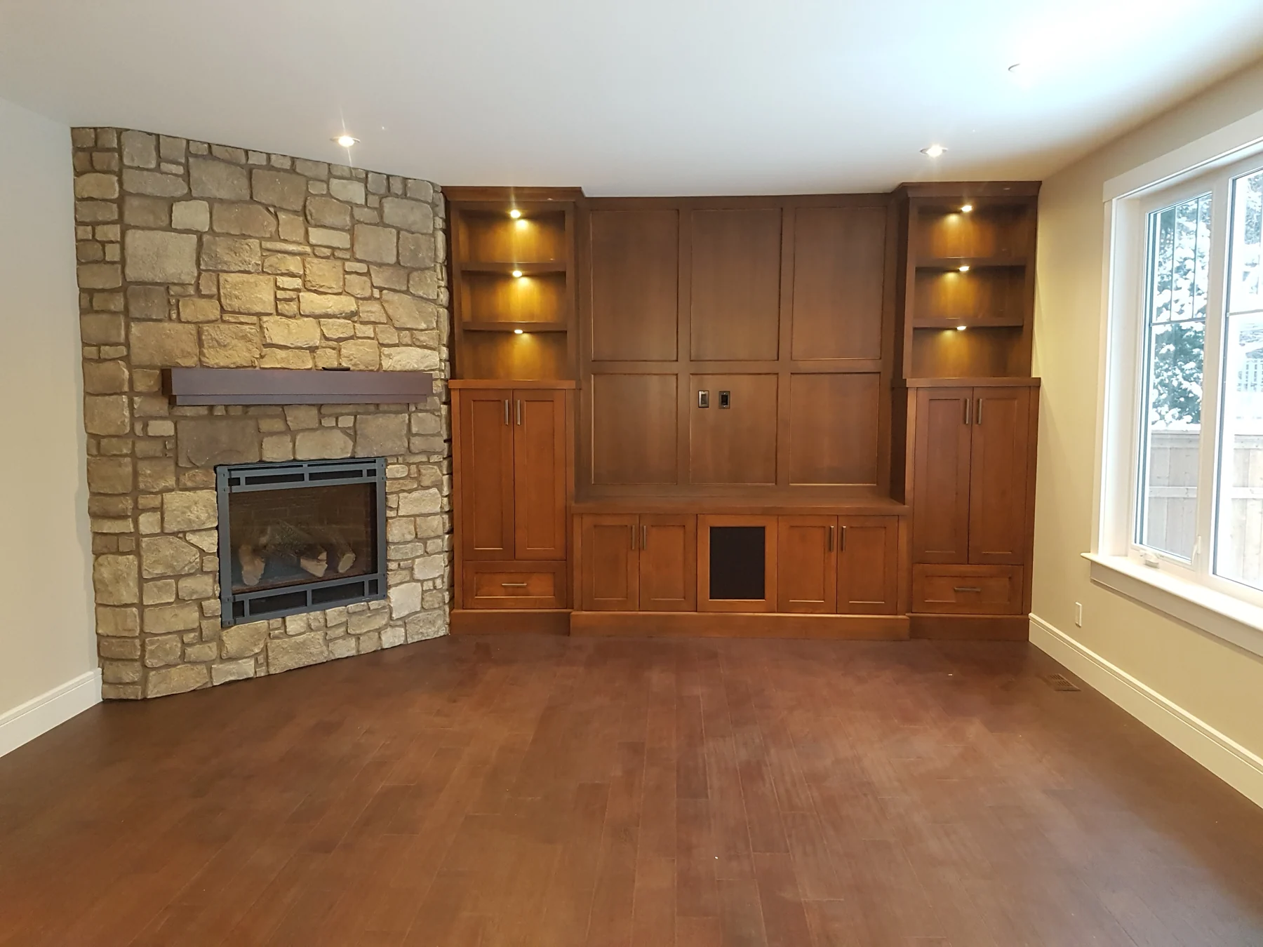 Living room with painted built-ins and stone fireplace feature wall